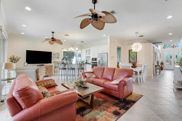 a living room with furniture a chandelier and a flat screen tv