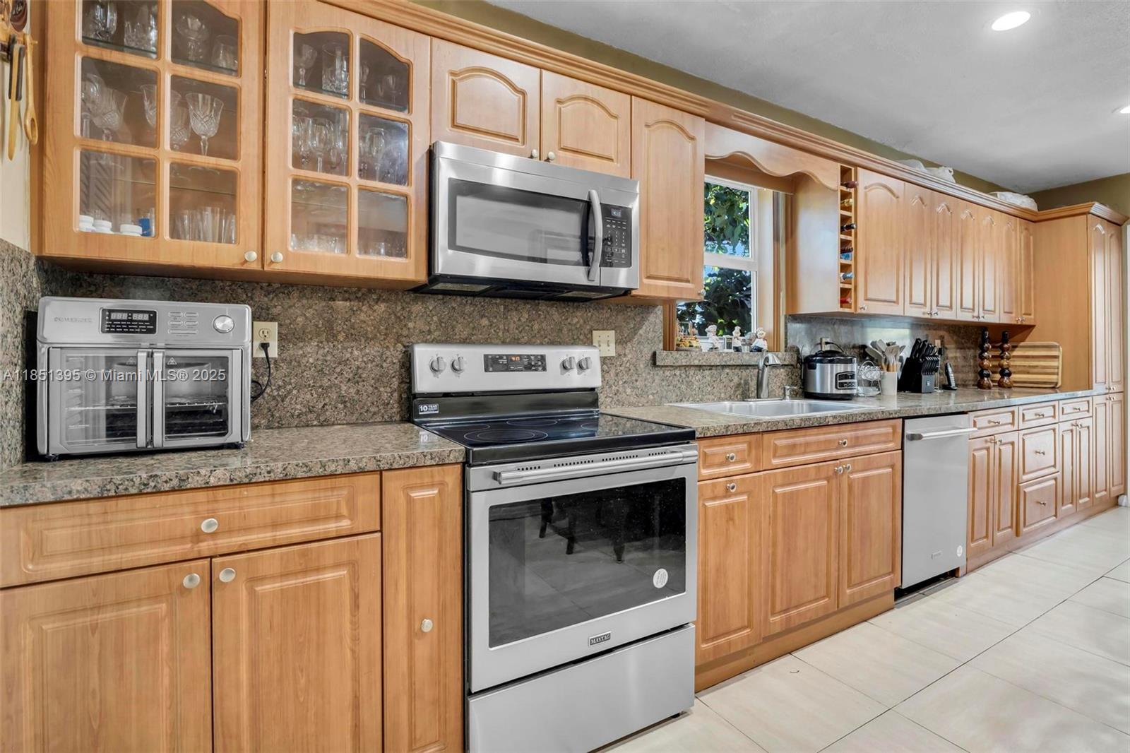 8711 Southwest 191st Street Cutler Bay, FL 33157 - Photo 23 of 56 a kitchen with stainless steel appliances granite countertop a stove microwave and cabinets