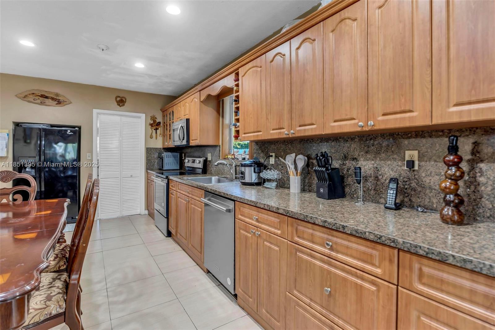8711 Southwest 191st Street Cutler Bay, FL 33157 - Photo 25 of 56 a kitchen with granite countertop a sink a stove and cabinets