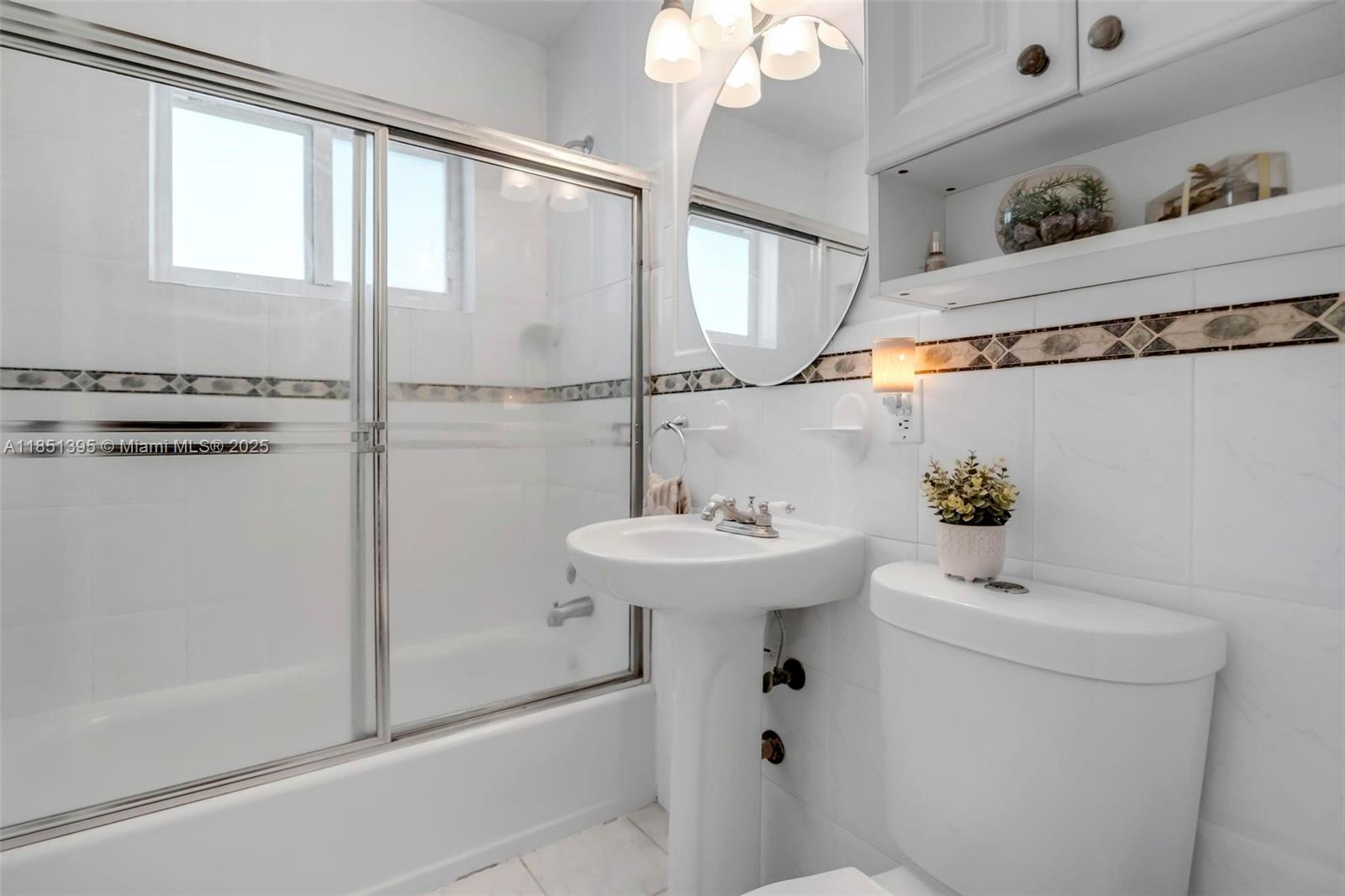 8711 Southwest 191st Street Cutler Bay, FL 33157 - Photo 31 of 56 a bathroom with a sink a mirror and a shower