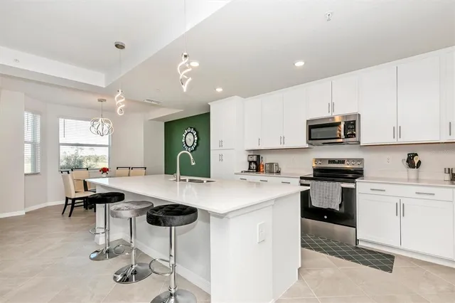 a kitchen with stainless steel appliances kitchen island a refrigerator sink and cabinets