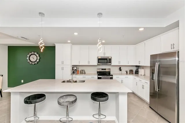 a kitchen with white cabinets and stainless steel appliances
