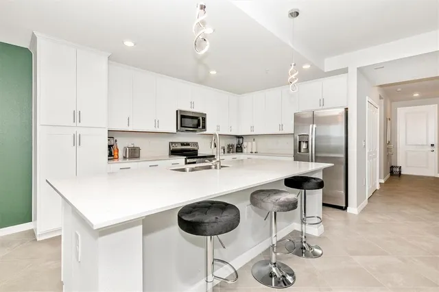 a kitchen with white cabinets and appliances