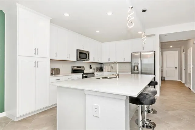 a kitchen with white cabinets and appliances