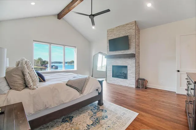a bedroom with a bed a window and wooden floor
