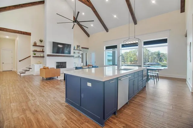 a living room with stainless steel appliances granite countertop furniture wooden floor and a large window