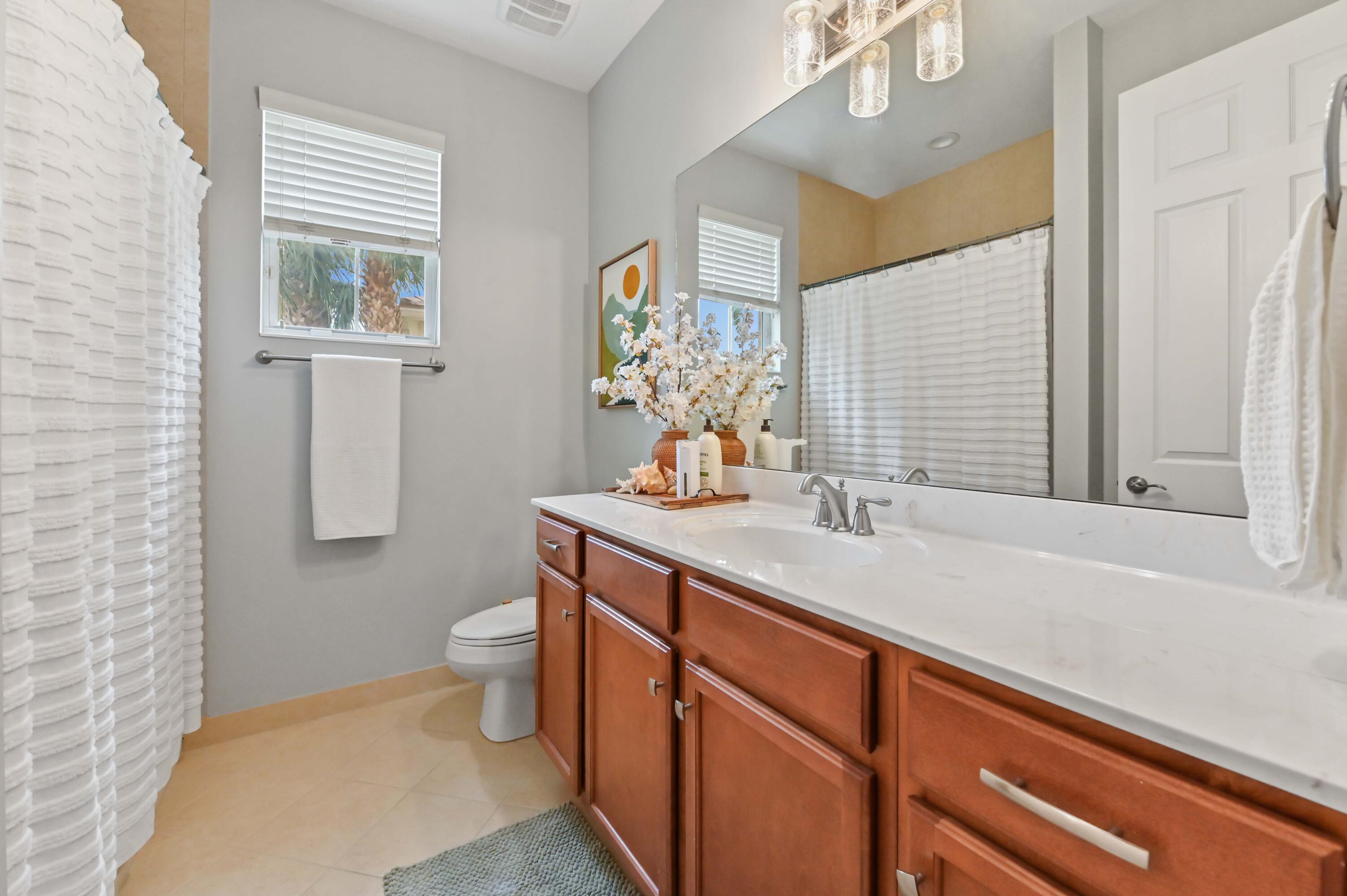 2910 Payson Way Wellington, FL 33414 - Photo 24 of 51 a bathroom with a granite countertop sink a toilet and shower