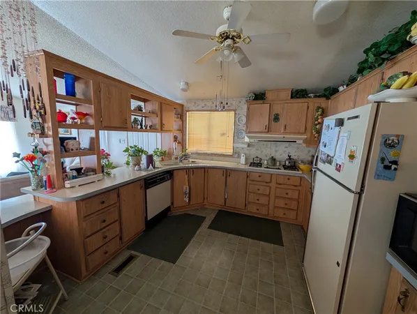 a kitchen with stainless steel appliances a refrigerator a sink a stove top oven a counter space and cabinets