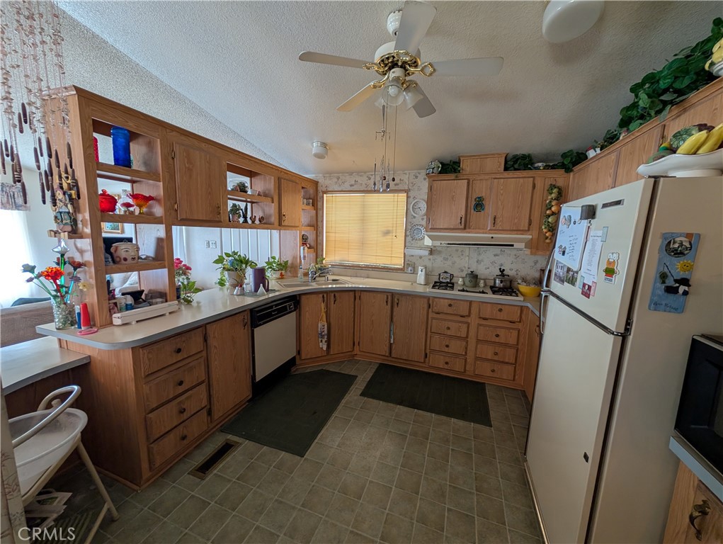 2500 Highway 59, Unit 103 Merced, CA 95348 - Photo 3 of 14 a kitchen with stainless steel appliances a refrigerator a sink a stove top oven a counter space and cabinets