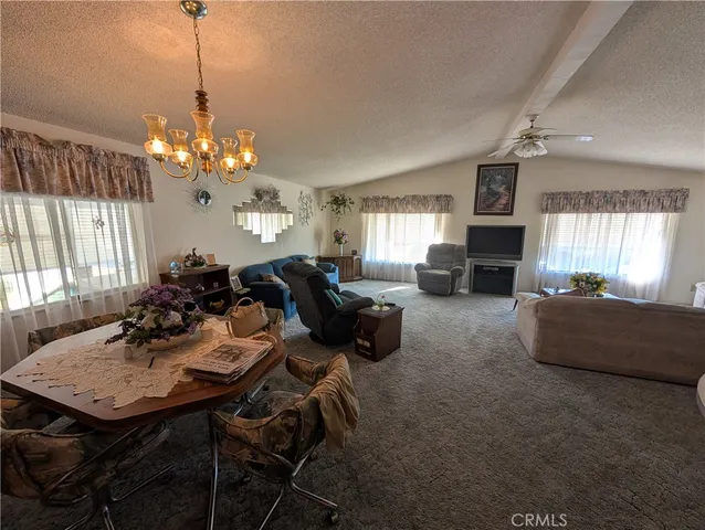 a view of a dining room with furniture and a chandelier