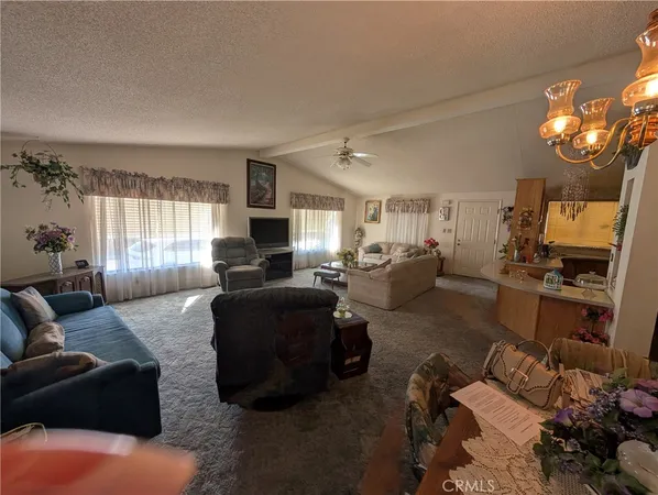 a living room with furniture window and kitchen view