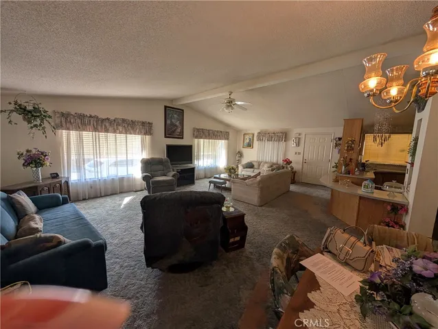 a living room with furniture window and kitchen view