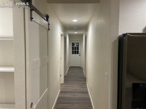 a view of a hallway with wooden floor and staircase
