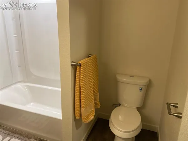 a white toilet sitting next to a bath tub