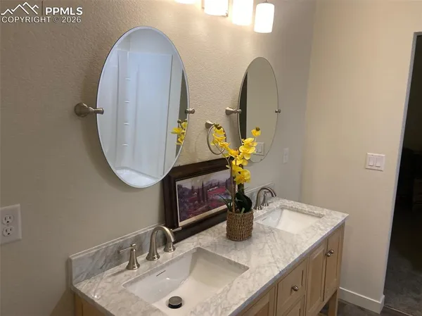 a bathroom with a granite countertop sink a mirror and vanity