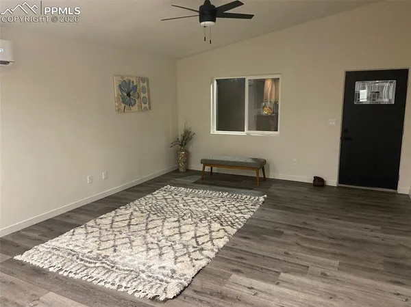 a view of a bedroom with wooden floor and a ceiling fan