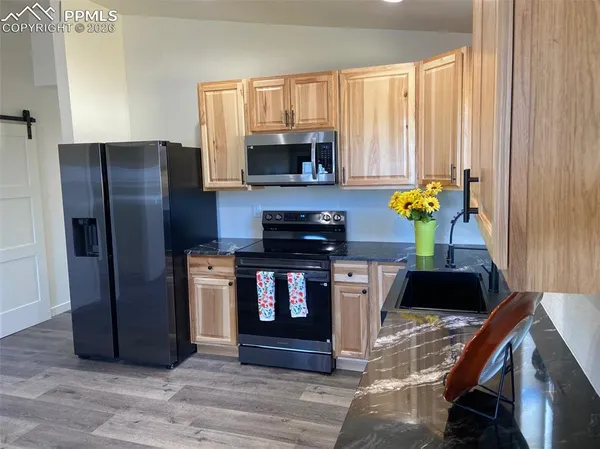 a kitchen with a refrigerator and a stove top oven