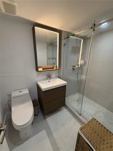 a bathroom with a sink mirror vanity and toilet