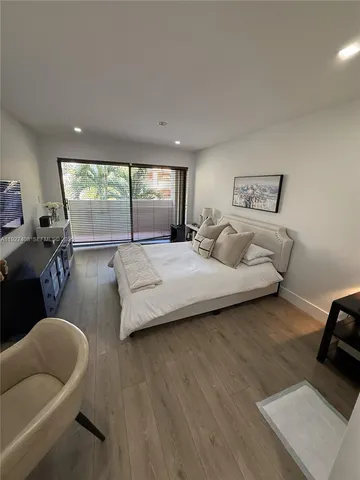 a bedroom with furniture and a large window