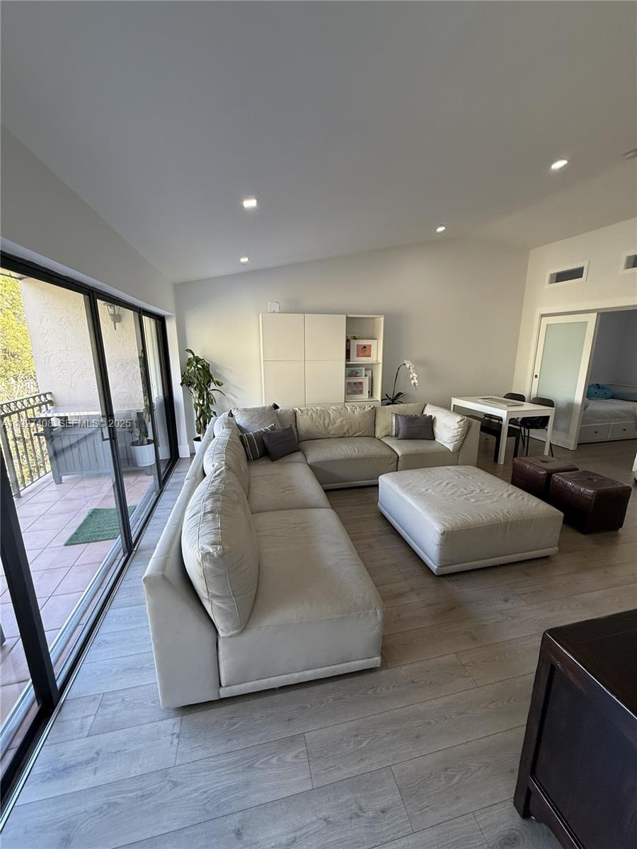 9001 Southwest 94th Street, Unit 208 Miami, FL 33176 - Photo 2 of 27 a living room with couches and large mirror with wooden floor