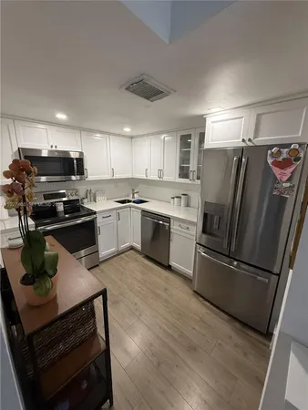 a kitchen with kitchen island a counter top space stainless steel appliances and cabinets