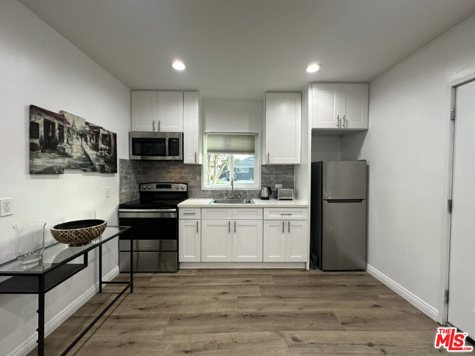 a kitchen with a refrigerator a stove and a sink