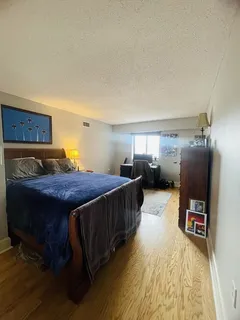 a spacious bedroom with a bed and a flat screen tv
