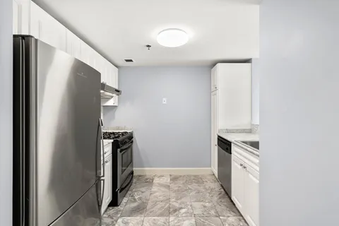 a kitchen with stainless steel appliances granite countertop a refrigerator and a stove