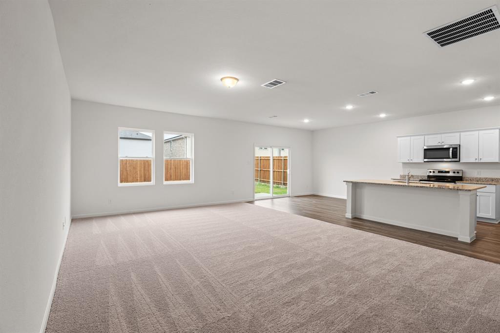 619 Colgate Circle Princeton, TX 75407 - Photo 9 of 31 a view of empty room with kitchen and window