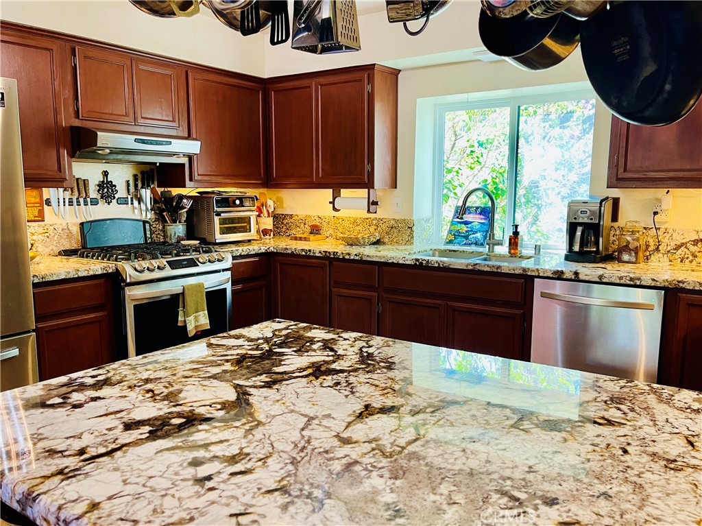 921 Piru Way Frazier Park, CA 93225 - Photo 3 of 54 a kitchen with stainless steel appliances kitchen island granite countertop a sink a counter space and a window