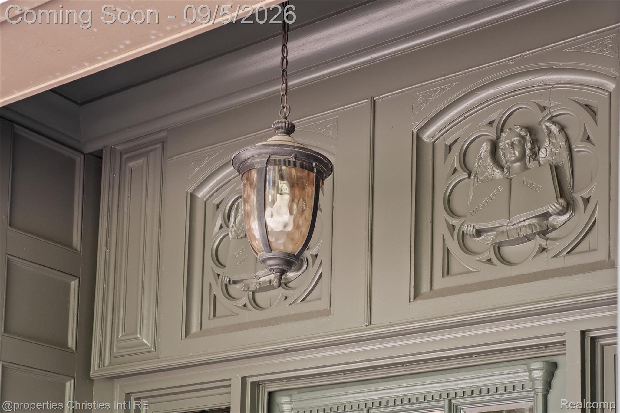 1540 Mill Race Road Rochester, MI 48306 - Photo 12 of 99 Elegant foyer showcasing ornate plaster wall panels with classical relief detailing, complemented by a pendant light fixture with a bronze finish and amber glass shade suspended from a chain