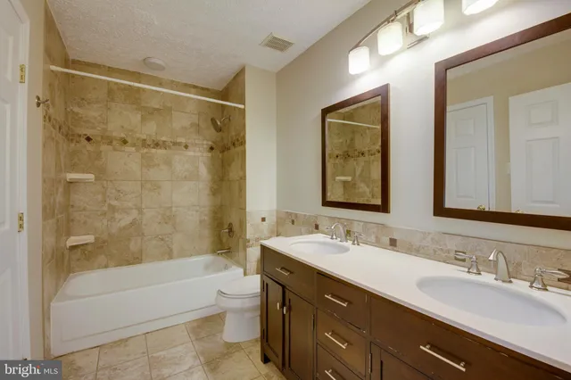 a bathroom with a double vanity sink mirror double and bathtub