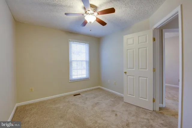 a view of room with a ceiling fan and a window