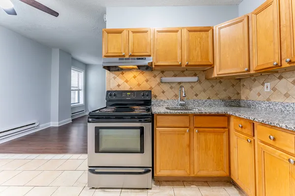 a kitchen with stainless steel appliances granite countertop a stove a sink and a microwave