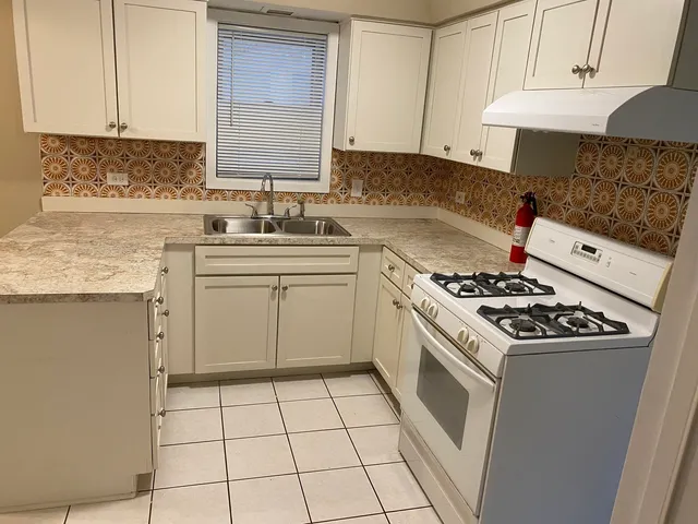 a kitchen with a stove sink and cabinets