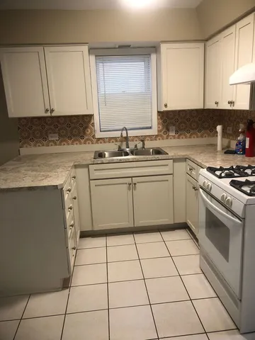 a kitchen with a stove sink and cabinets