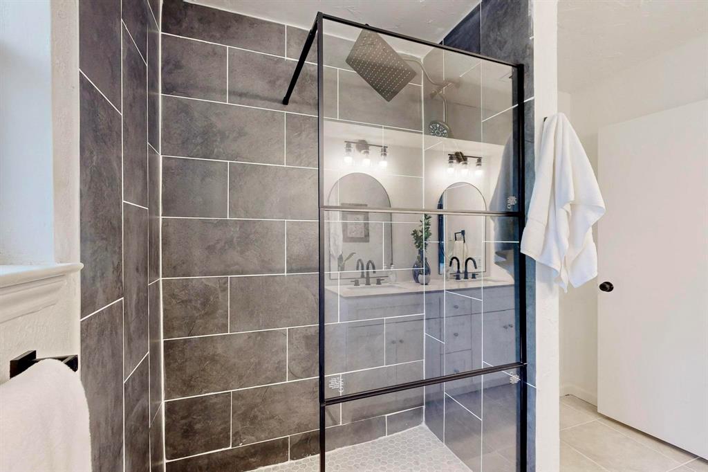 3965 Singleleaf Lane Fort Worth, TX 76133 - Photo 19 of 39 Walk-in shower with dark rectangular tile walls and a hexagonal tile floor