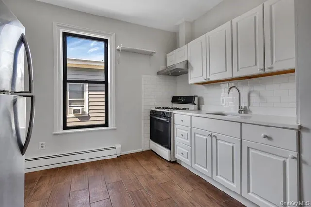 a kitchen with granite countertop white cabinets and white appliances