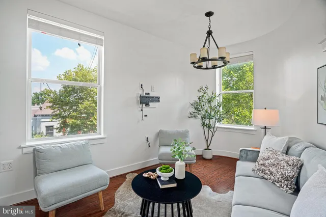 a living room with furniture a window and a chandelier