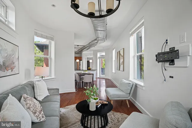 a living room with furniture a chandelier and a table