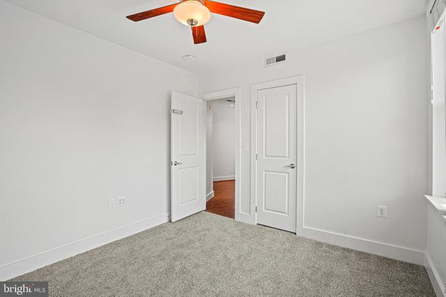 an empty room with a ceiling fan and a window