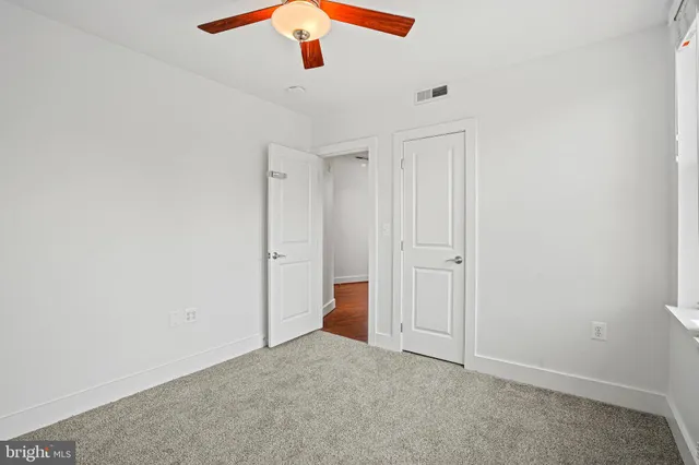 an empty room with a ceiling fan and a window