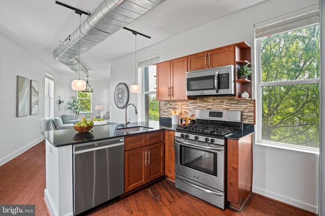 a kitchen with stainless steel appliances granite countertop a stove a sink and a microwave