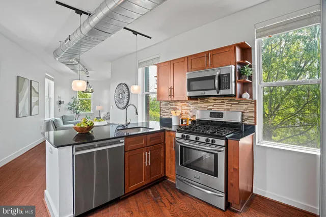 a kitchen with stainless steel appliances granite countertop a stove a sink and a microwave