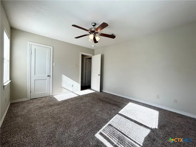 a view of a livingroom with a ceiling fan and window