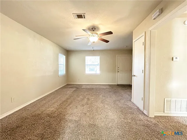 a view of a livingroom with a ceiling fan and window