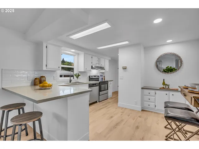 a kitchen with stainless steel appliances kitchen island granite countertop a sink cabinets and wooden floor