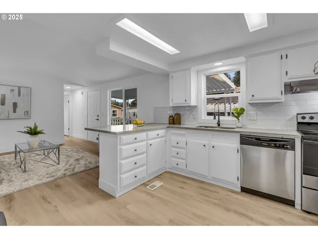 a kitchen counter with kitchen island granite countertop a sink a counter space and cabinets