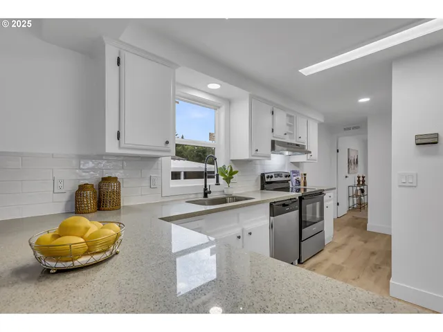 a kitchen with stainless steel appliances granite countertop a sink a stove and cabinets