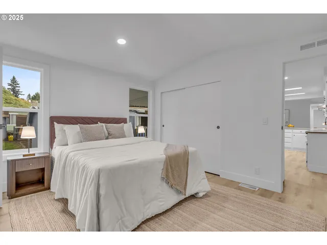 a spacious bedroom with a bed and wooden floor